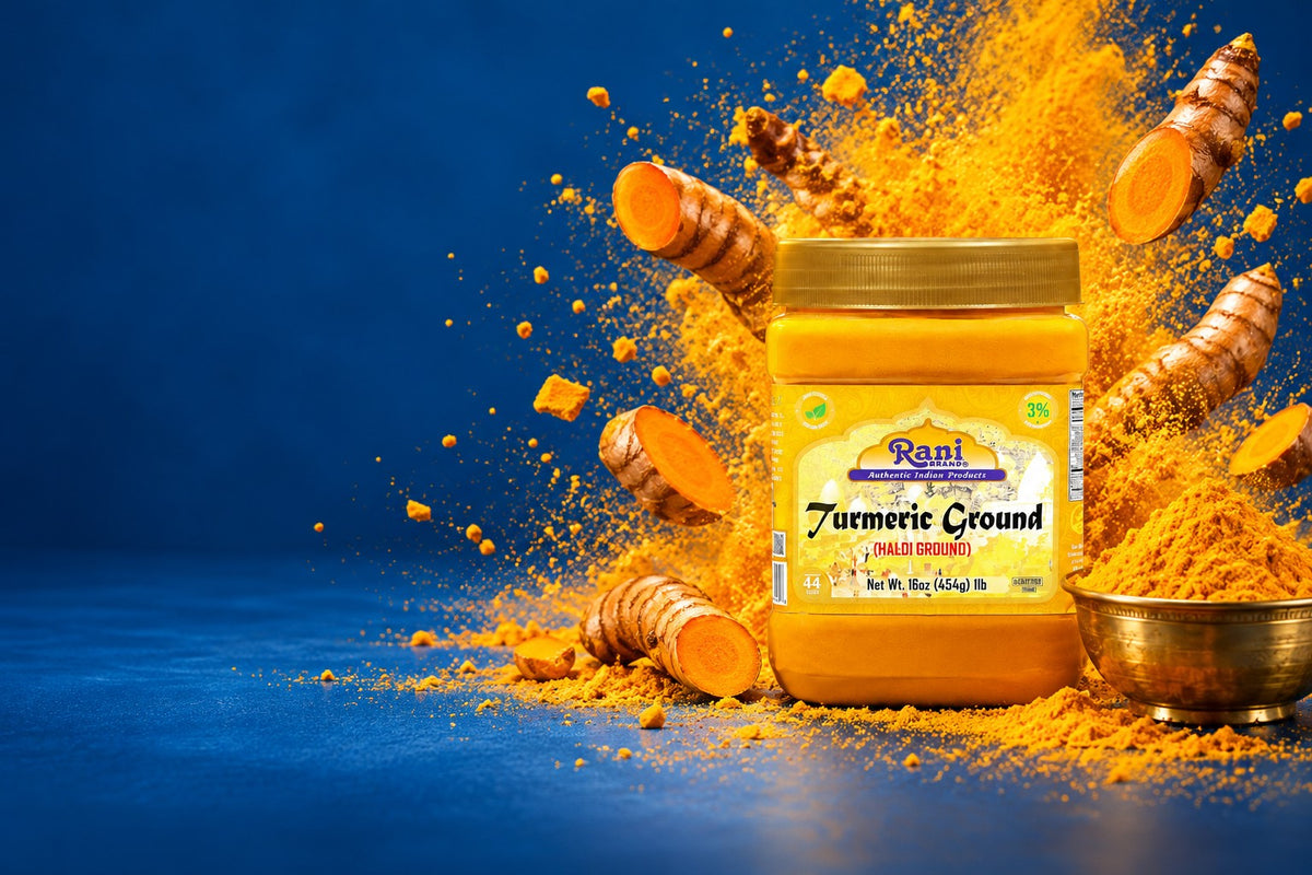 Rani Turmeric Ground jar with a burst of golden turmeric powder and fresh turmeric roots on a deep indigo backdrop